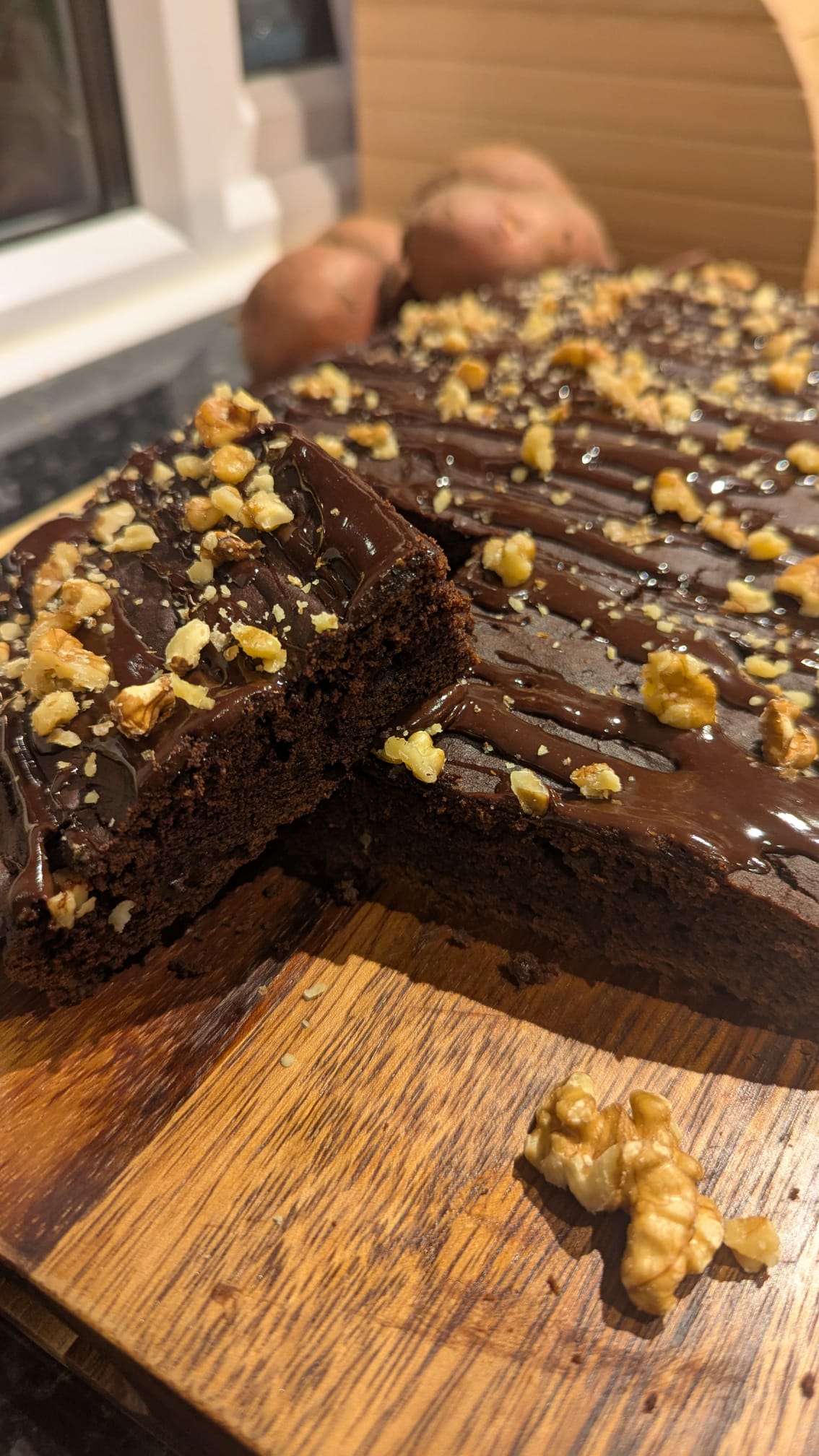 Freshly baked teff brownie topped with walnuts and chocolate drizzle